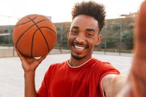 man smiling and holding a basketball